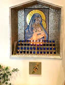 This mosaic is handmade from glass and marble portraying Virgin holding baby Jesus against her chest.